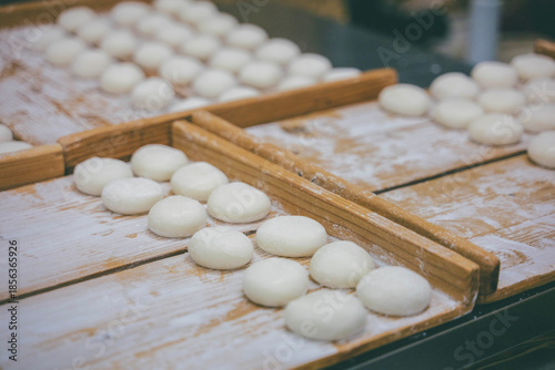 Rows of traditional Japanese mochi on wooden boards in a workshop