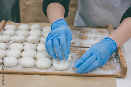 Artisan hands in blue gloves making traditional Japanese mochi rice cakes
