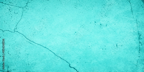 Vintage blue painted plaster wall texture with a rough grunge pattern on an old blank concrete surface provides a weathered turquoise backdrop for art and design