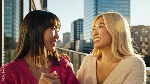 Two young women looking at smartwatch on city rooftop with skyscrapers