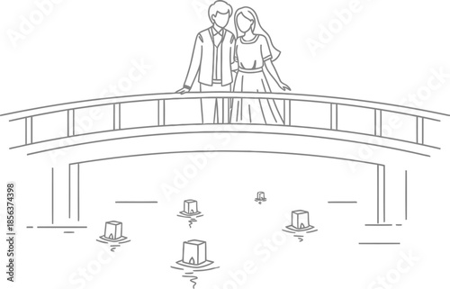 A young romantic couple stands closely together on an arched bridge watching floating lanterns illuminate the water below them