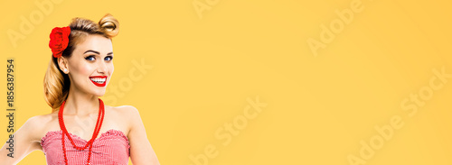 Portrait image of cute blond pin up woman. Expressive happy smile girl in pinup cloth. Retro fashion vintage ad concept. Isolated orange yellow background with free text space. Wide banner