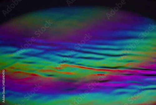 Holographic foil slowly shifting colors with light, iridescent reflections, abstract luxury background, seamless loop, 4K