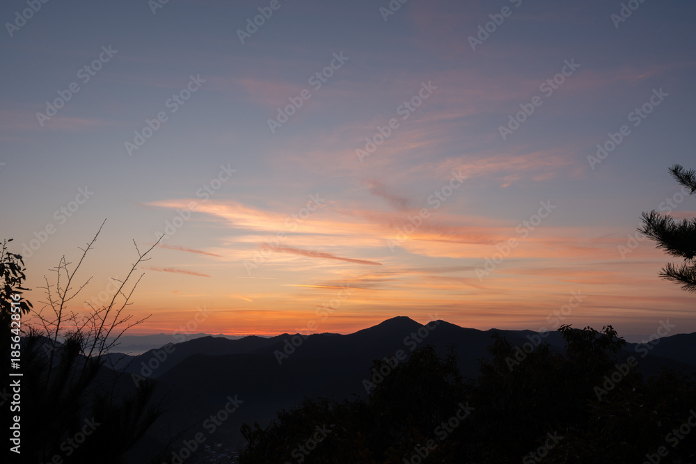 Fototapeta premium 朝焼けの空と山々のシルエット