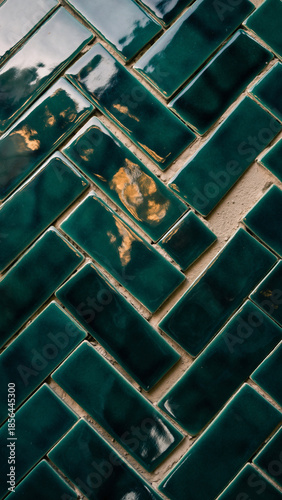 Vertical close-up of glossy, green ceramic subway tiles arranged in a traditional running bond pattern with contrasting white grout. The beveled edges of the vintage-style tiles catch reflections, 
