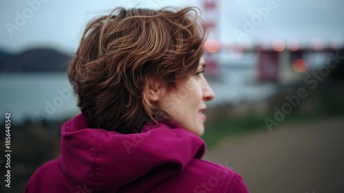 A person stands by the shore. The day is calm, and the surrounding scenery is serene. The view captures the essence of outdoor relaxation