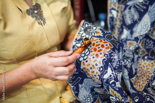 Obraz na plátně Woman Creating Traditional Batik Textile Using Hot Wax and Canting in Indonesia