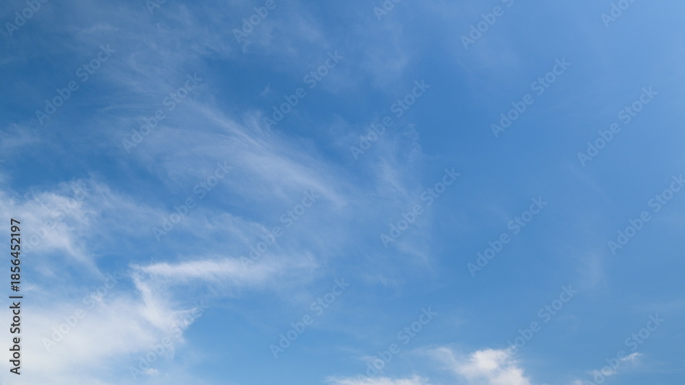 Naklejka premium Time lapse. A Beautiful Clear Sky adorned with Wispy Clouds enhances the stunning view of nature and serenity