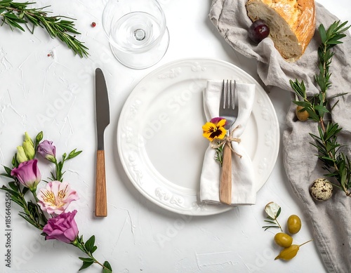Elegant table setting with white plate, flowers, and cutlery