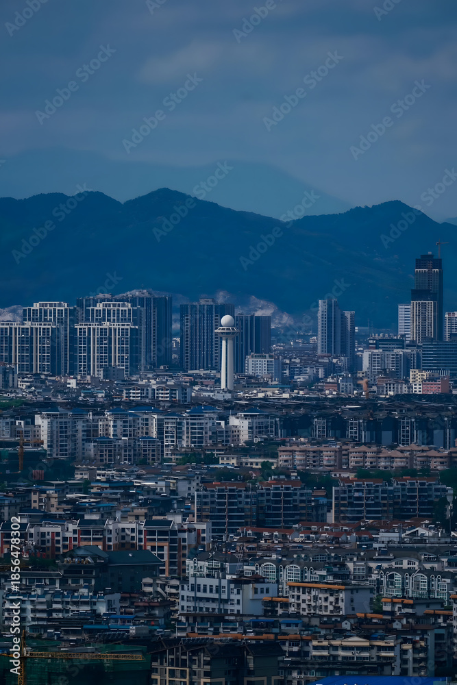 Obraz premium Modern City Skyline with Mountain Backdrop - Urban Landscape View