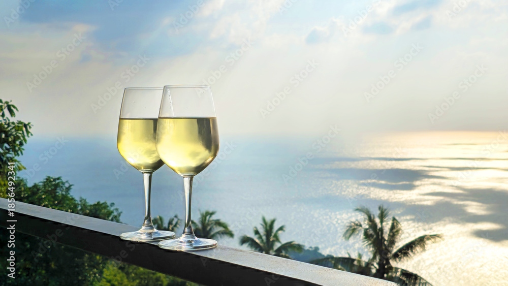 Obraz premium Two glasses of white wine ocean view at sunset, Island Ko Tao, Surat Thani, Thailand, Southeast Asia.