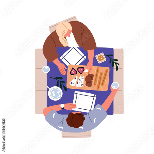 Couple eating together. Man and woman sitting at table from top overhead view...