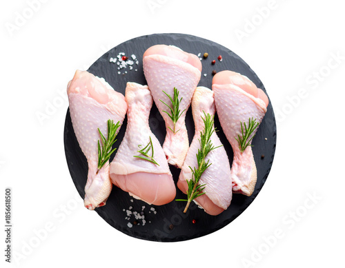 flesh from chickens. On a slate black platter, fresh raw chicken drumsticks are prepared for cooking. on a background of rough stone. Close-up, cut out