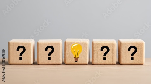 Wooden blocks with question marks and a light bulb symbolizing creativity, curiosity, and idea generation for problem-solving concepts