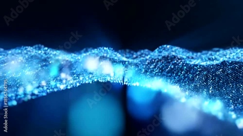 Abstract blue wave of glittering particles creating a futuristic and dynamic digital landscape.