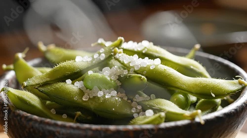 Steaming edamame pods sprinkled with sea salt close up