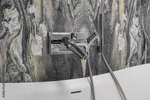 Photography Modern wall mounted bathroom mixer with handheld shower against Cipollino marble stone wall in luxury minimalist bathroom interior