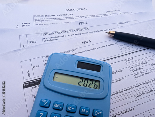 Photography Indian income tax return ITR 1,2,3 forms with blue calculator showing 2026 and b