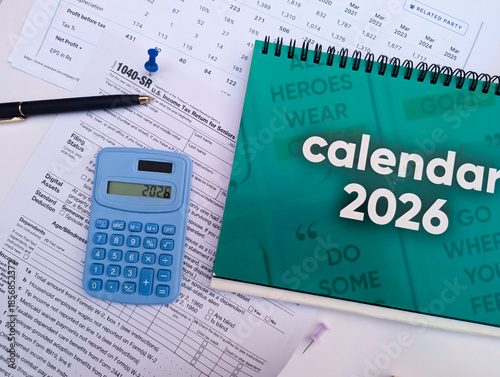 calendar 2026 with US tax form and blue calculator for financial planning