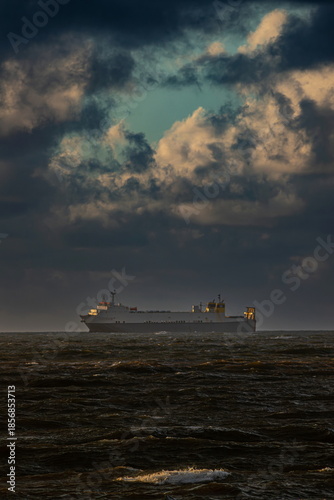Ship on the horizon under cloudy sky