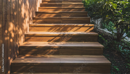Wooden outdoor staircase with dappled sunlight and lush green foliage creating a natural pathway upwards in a serene garden setting