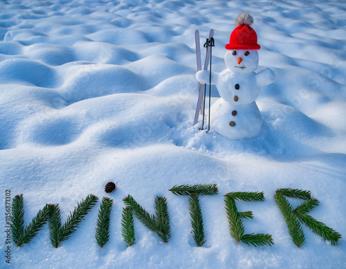 Bałwan śniegowy stojący na ośnieżonym polu z napisem 