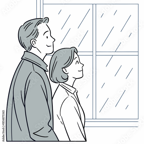 A couple stands side by side gazing out of a window as rain falls outside lost in peaceful contemplation