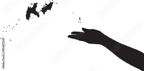 Silhouette of hand releasing particles into air