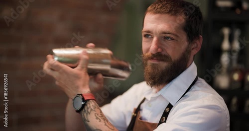 Bartender Expertly Mixes a Cocktail in a Metal Shaker, Showcasing Skill and Passion in a Stylish Bar Setting.