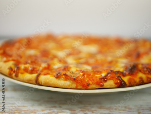 Wallpaper Mural Whole Pizza Served on Plate Viewed from Low Angle Emphasizing Crust Thickness Toppings and Casual Home Dining Style Torontodigital.ca