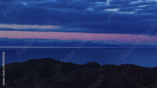 Issyk Kul lake Kyrgyzstan snowy mountains at sunset aerial view