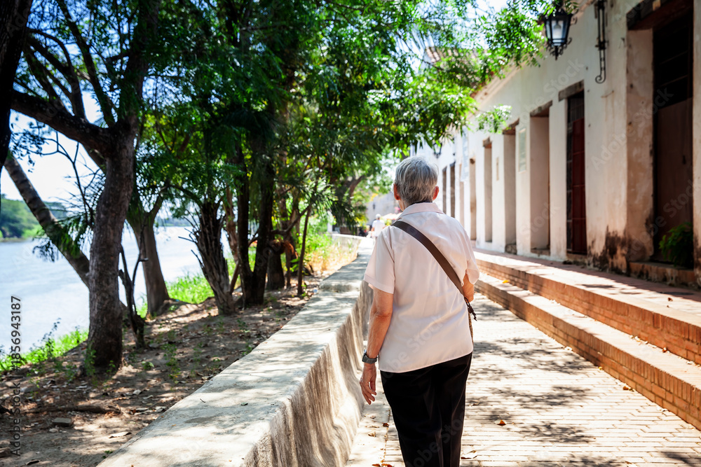 custom made wallpaper toronto digitalSenior travel concept. Senior woman walking at the beautiful streets of the colonial Heritage Town of Santa Cruz de Mompox in Colombia.