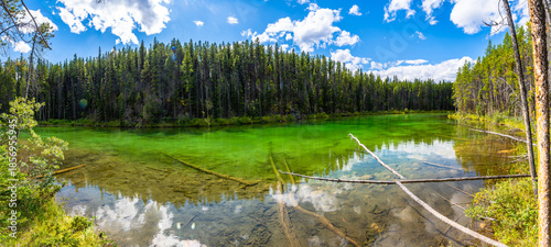 Tableau sur toile Herbert lake reflecting clouds and forest in banff national park