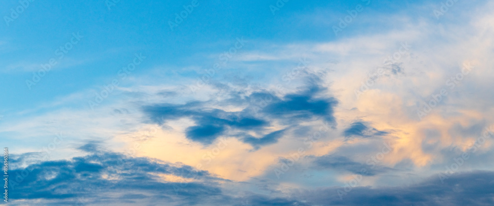 Obraz premium Dramatic blue sky with golden clouds at sunset with soft color transitions and atmospheric light