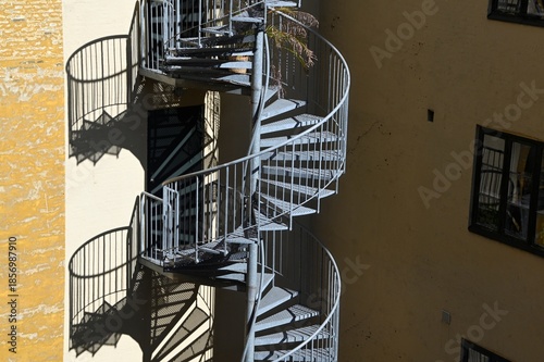 Outdoor spiral staircase in Copenhagen, Denmark with shadows