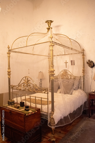 Canvastavla Elegant vintage canopy bed with delicate netting in a traditional hacienda bedro