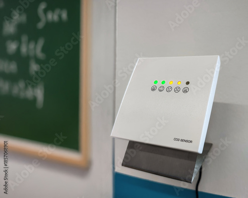 CO2 monitor warning to ventilate classroom. Carbon dioxide monitor with green yellow indicator lights signaling rising CO2 levels and poor indoor air quality. Preventive health measures