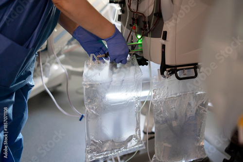 Photos Nurse connecting dialysis solution bags to medical equipment
