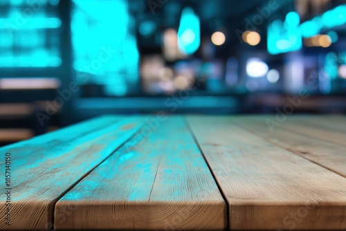 Empty rustic wooden table surface focusing on foreground with blurry neon blue light bokeh background in a dark bar setting