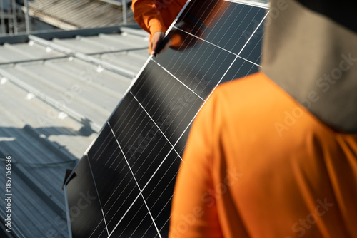 Workers install solar panels on a rooftop in an urban setting during daylight hours