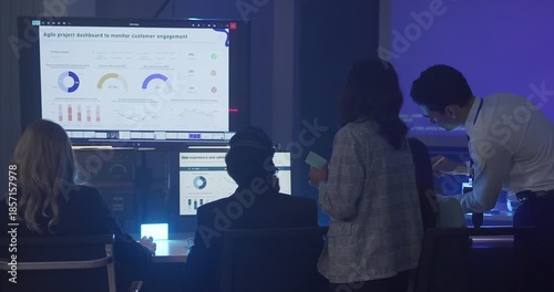 A focused team wearing headsets monitors live analytics dashboards and collaborates in modern control room. Highlighting customer support, data driven decision making, coordinated incident response.
