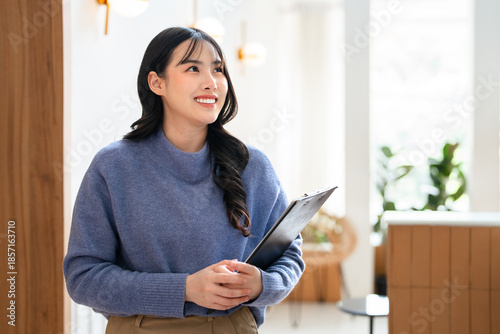 Schilderij op canvas Young business woman freelancer holding document flie standing in cafe