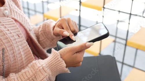 A young woman works on a laptop while sitting in a modern café, enjoying a quiet moment with coffee, reflecting a freelance lifestyle, remote work, and productivity in a cozy space.