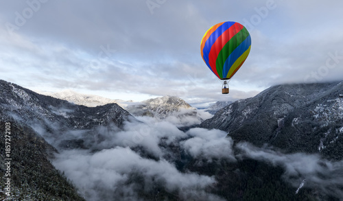 фотографія Colorful Hot Air Balloon Over Snowy Mountain Valley With Clouds in Aerial Advent