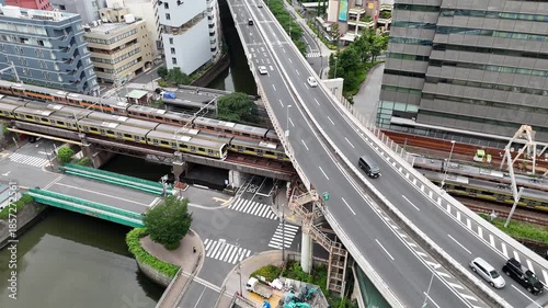 Aerial view of Tokyo urban highway and trains on railway lines along city river