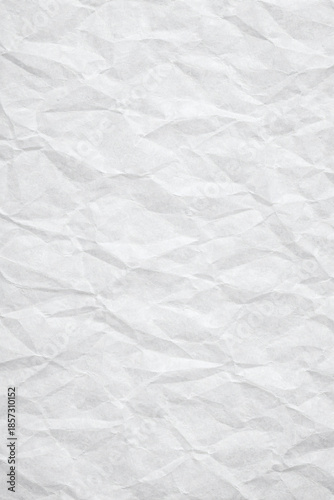 A high-contrast image of a white sheet of paper that is heavily crumpled, creating deep shadows that highlight its textured surface.