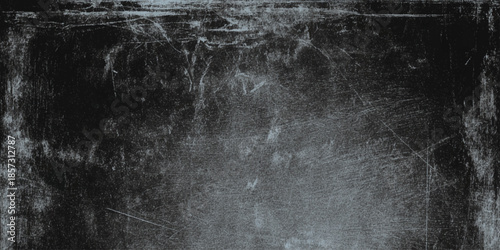 A stark textured black and white image depicting a distressed scratched and grainy surface with abstract forms