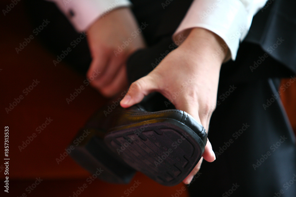Fototapeta premium Professional business man tying to put on the dress shoes. A professional, stylish business setting with emphasis on detail and refinement of a fine gentlemen