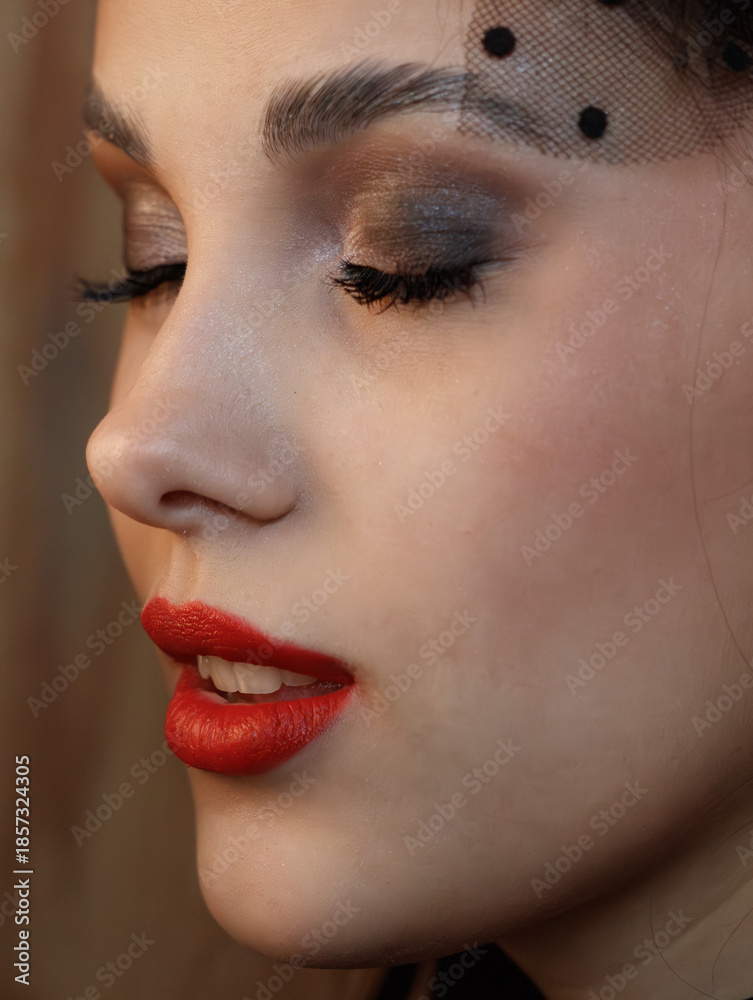 Fototapeta premium A woman with red lipstick and a black hat