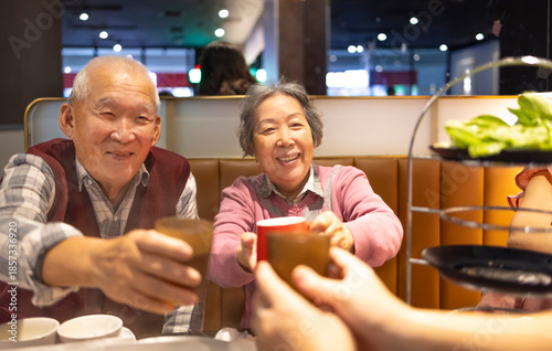 Happy Asian senior couple celebrating Chinese New Year in restaurant